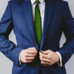 Man dressed in business suit and green leaves as tie representing a natural job in defense of a green environment.