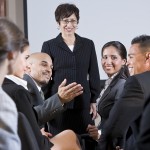 Diverse Businesspeople Conversing, Woman At Front