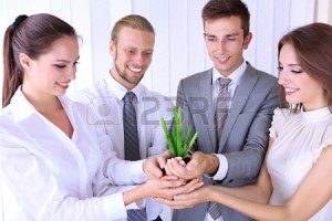21514934-business-team-holding-together-fresh-green-sprout