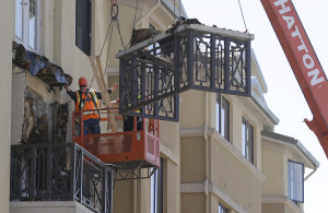 Workers remove part of a balcony that collapsed at the Library Gardens apartment complex in Berkeley, Calif., Tuesday, (AP Photo/Jeff Chiu)