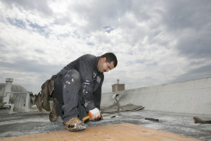 Roofer Joel Camberos with Hull Brothers Roofing & Waterproofing resurface townhomes roofs at the Marina del Rey seaside community of Los Angeles on Aug. 25, 2015. Roofers are reveling in the uptick in business as homeowners ready for the prospect of downpours after four years of dry weather. (AP Photo/Damian Dovarganes)