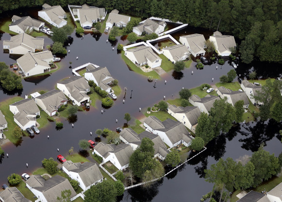 This aerial photo show flooding around homes in the Carolina Forest community in Horry County, between Conway and Myrtle Beach, S.C. The Carolinas saw sunshine Tuesday after days of inundation, but it could take weeks to recover from being pummeled by a historic rainstorm that caused widespread flooding and multiple deaths. (Janet Blackmon Morgan/The Sun News via AP)