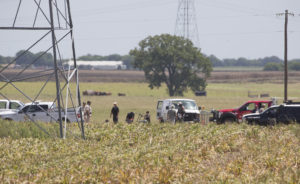 Investigators surround the scene in a field near Lockhart, Texas where a hot air balloon carrying at least 16 people collided with power lines Saturday, July 30, 2016,  causing what authorities described as a "significant loss of life."  (Ralph Barrera/Austin American-Statesman via AP)