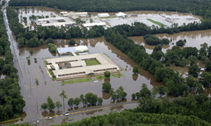 This aerial photo over Hammond, La., shows flooded Hammond Eastside Elementary Magnet School and Hammond High Magnet School after heavy rains inundated the region Saturday, Aug. 13, 2016. Louisiana Gov. John Bel Edwards says more than 1,000 people in south Louisiana have been rescued from homes, vehicles and even clinging to trees as a slow-moving storm hammers the state with flooding. (AP Photo/Max Becherer)