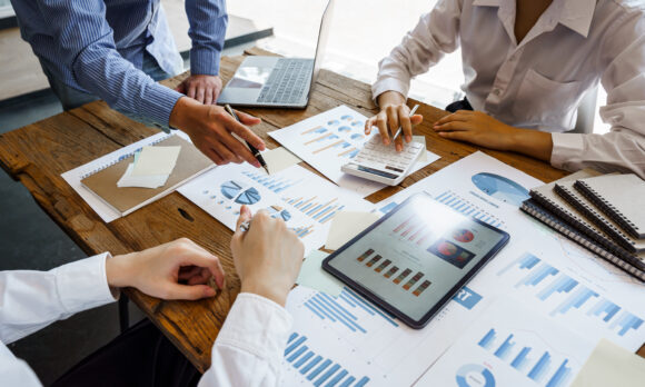 Team work discussing in valuation data in meeting room, three business people with accounting paper charts.