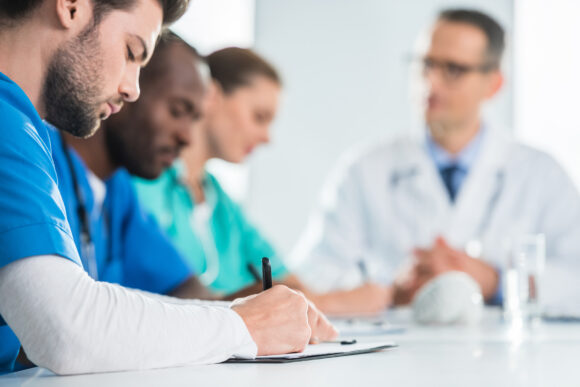 doctor writing in clipboard