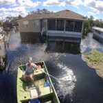 Resident Mike Kelley navigates flooded streets in the Mullet Lake neighborhood, Wednesday, Oct. 5, 2022, in Geneva, Fla., as floodwaters from Lake Harney and the St. Johns River continue to rise following historic levels of rainfall from Hurricane Ian last week. (Joe Burbank/Orlando Sentinel)