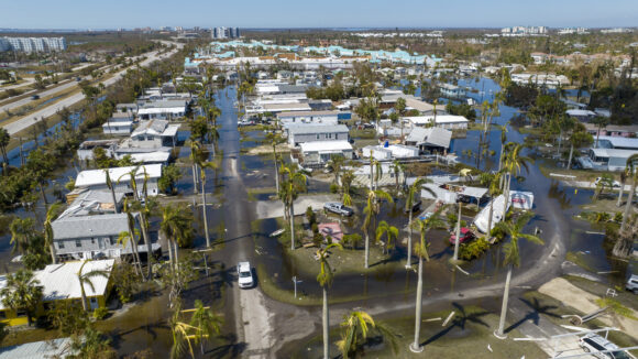 Water floods a damaged trailer park in Fort Myers, Fla., on Saturday, Oct. 1, 2022, after Hurricane Ian passed by the area. (AP Photo/Steve Helber)
