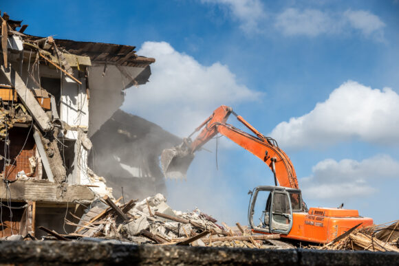 Big bulldozer earth mover or digger on tracks standing on pile o