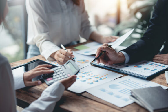 Business people meeting and calculating profit and loss The balance sheet for each quarter look at graph and chart to suggest new marketing strategy idea.