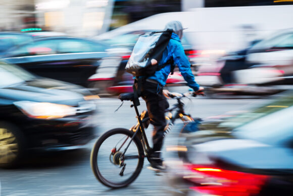 picture of a bicycle messenger in busy city traffic with camera made motion blur effect