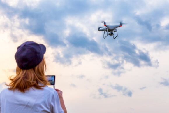 Woman drives a drone towards the cloudy sky