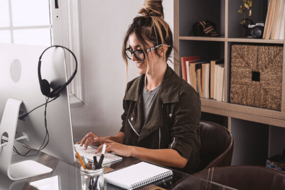 Adult woman type on laptop computer and smile happy for smart working free office home activity - modern people online job remote work lifestyle - female young age at the desktop typing and enjoy business online
