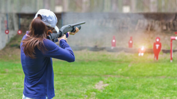 woman in practice shooting gun riffle in martial arts for self defense in an emergency case