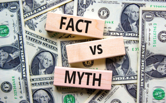 Fact vs myth symbol. Concept words Fact vs myth on wooden blocks on a beautiful background from dollar bills. Business, finacial and fact vs myth concept. Copy space.