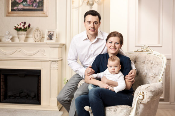 Young happy family with a baby indoors