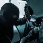 Vehicle Thief Concept Photo. Caucasian Car Thief in Black Mask.