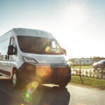 New Delivery Van / Truck Driving Through the Beautiful Suburban Town Area. Postal Delivery Service. Front View Shot