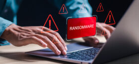 Malware attack virus alert. Person use laptop with virtual warning sign with ransomware word. warning notification, Cyber threats.