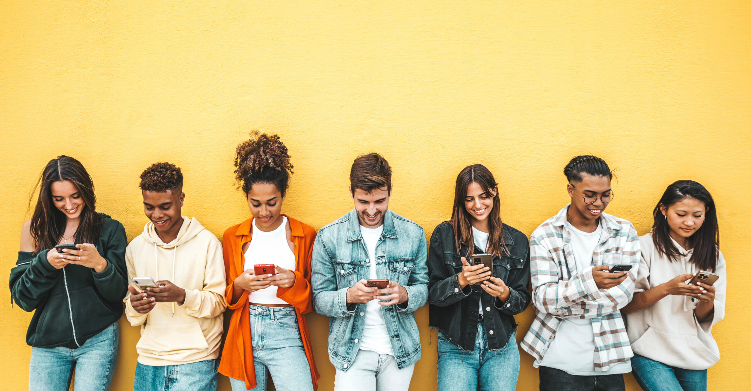 Group of young people using smart mobile phone device outside - Teenagers addicted to social media - College students watching smartphone in university campus - Modern technology concept