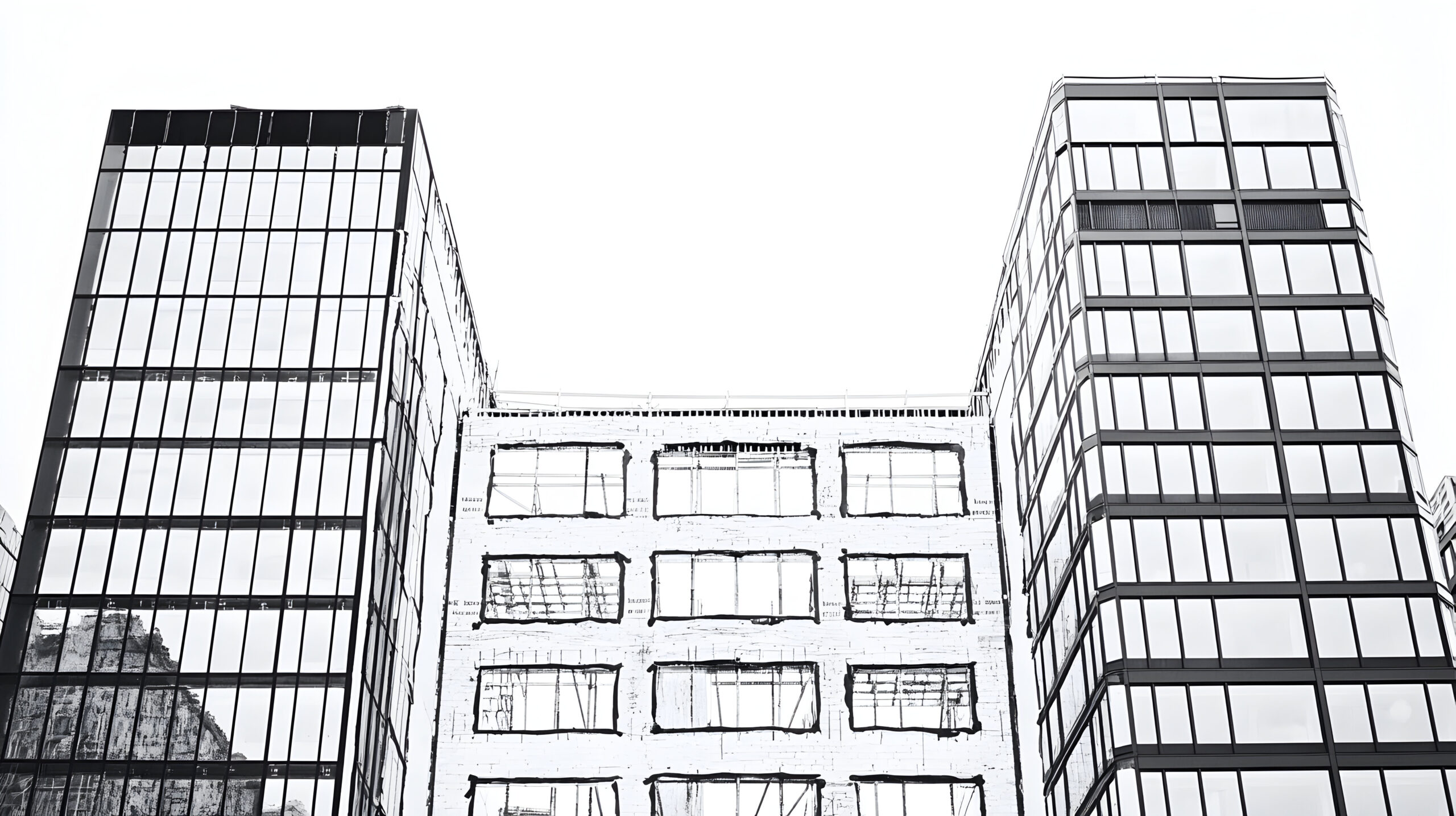 Three modern buildings, two glass skyscrapers flanking a smaller, older building under renovation.
