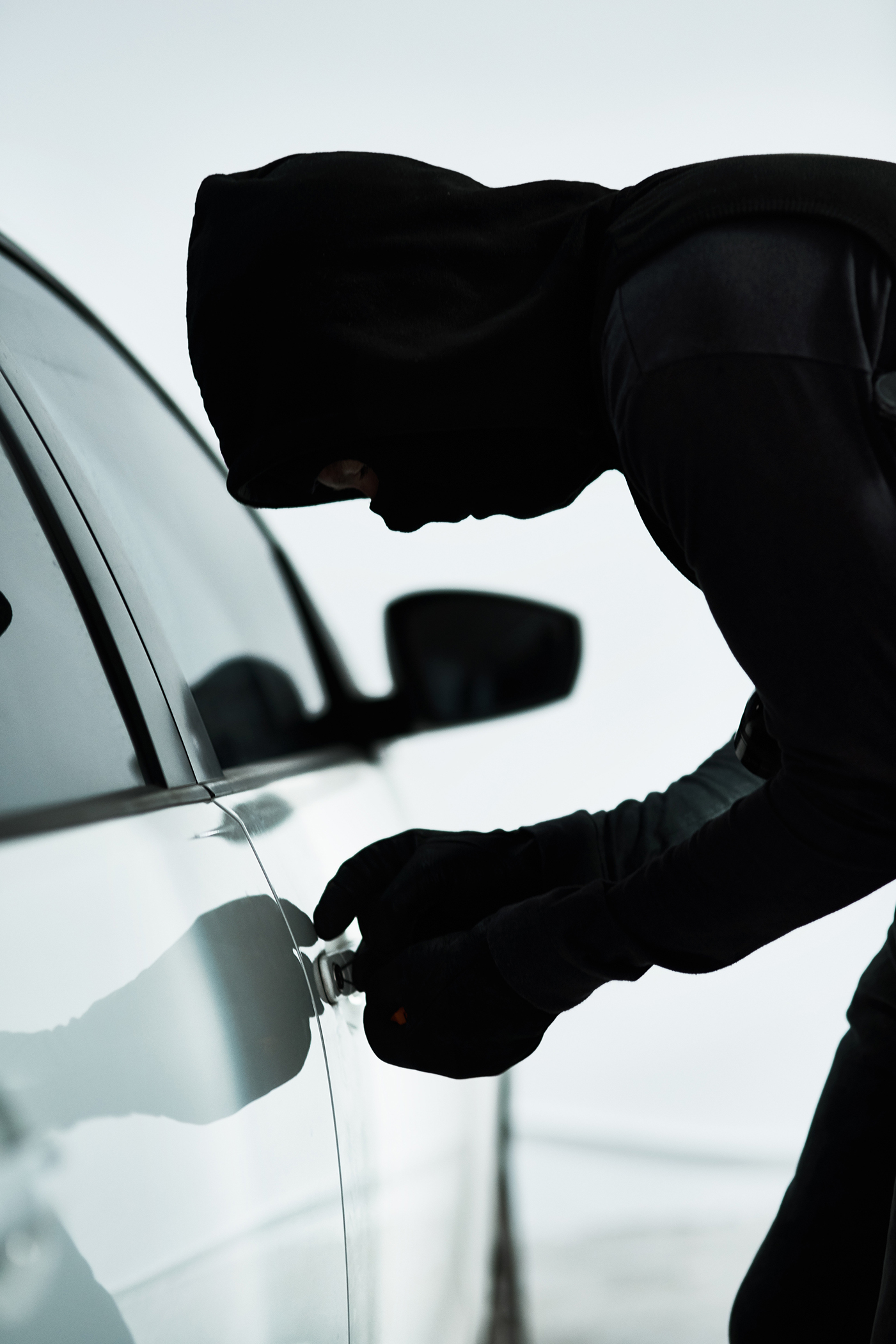 Man, car and steal with theft tool, picking lock and illicit behaviour or automobile jacking. Criminal, makeshift key and hooded offender or disabling vehicle alarm, parking lot and illegal burglary.