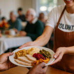 Volunteer serving Thanksgiving meal to community members at a soup kitchen.