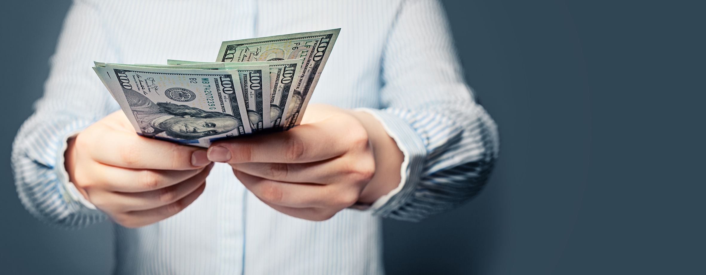 Hands giving money US dollars on blue background