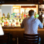 Lonely man in shirt sitting at bar desk