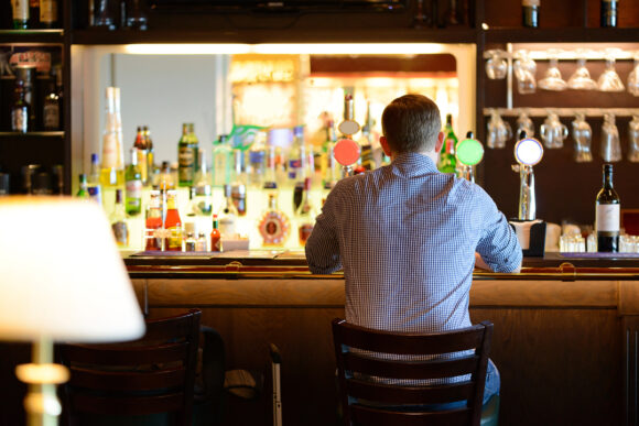 Lonely man in shirt sitting at bar desk