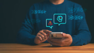 Person using smartphone with AI alert icon for artificial intelligence security risk, digital technology warning, and communication notification on mobile device.