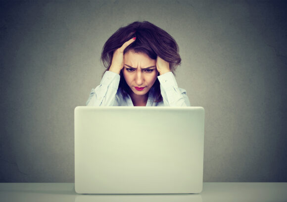Tired stressed business woman using a laptop