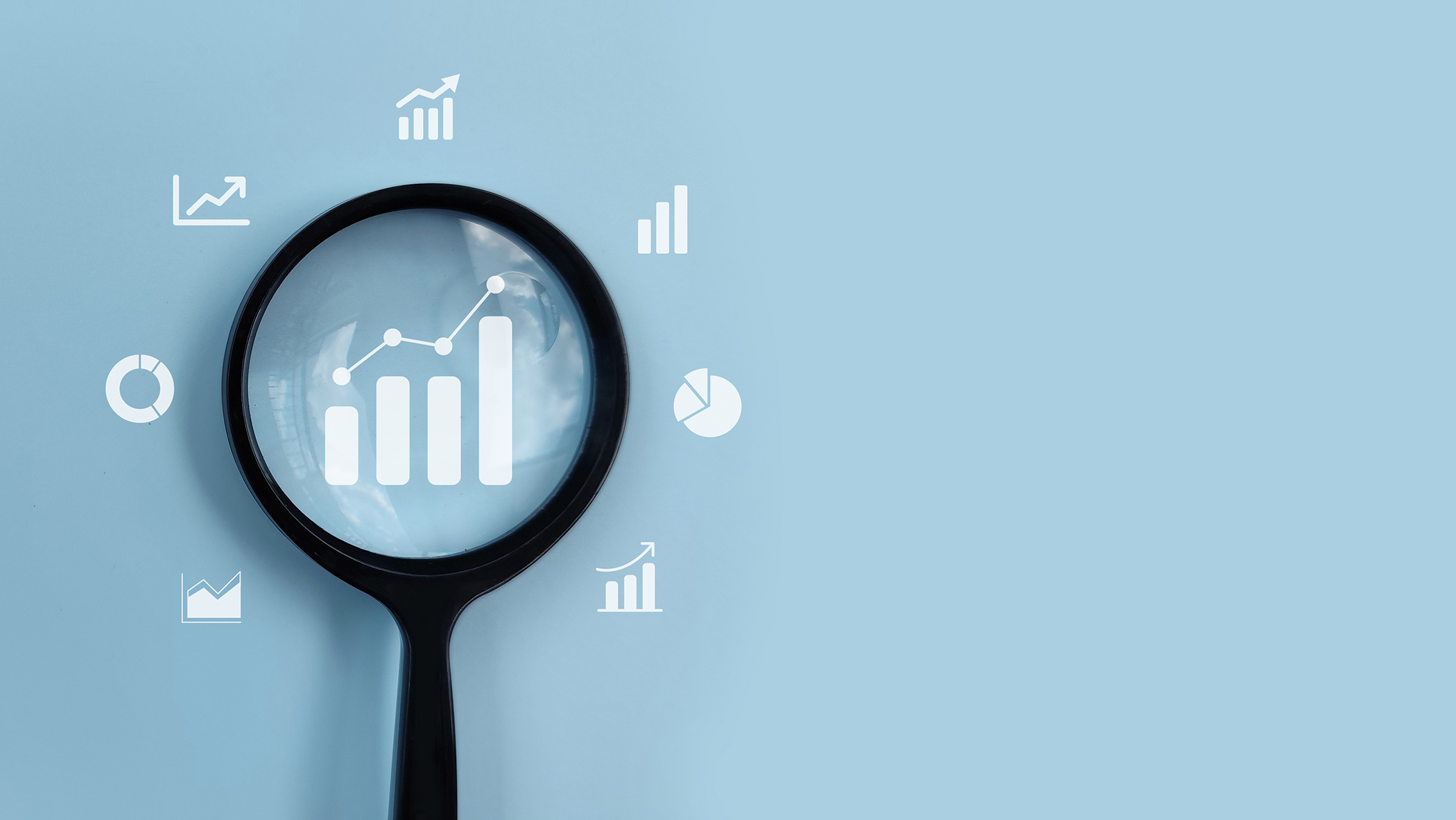 Magnifying glass analyzing business growth charts and data icons