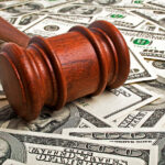 Wooden gavel laying on American dollars