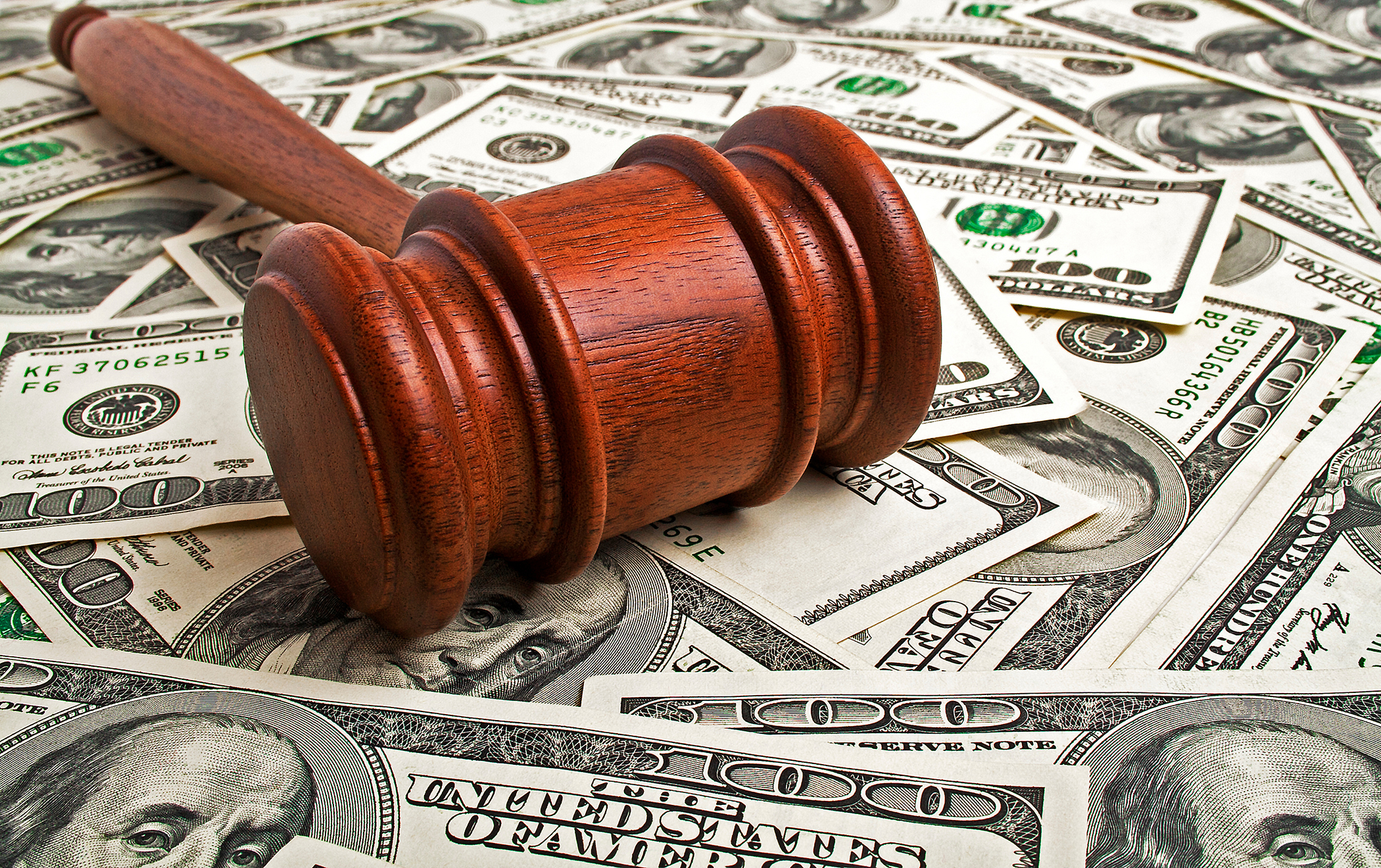 Wooden gavel laying on American dollars