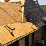 House with new roof being installed after hail damage