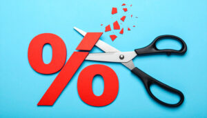 Scissors cutting red percentage symbol representing discount or
