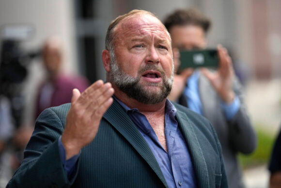 Right-wing conspiracy theorist Alex Jones speaks to the media after arriving at the federal courthouse for a hearing in front of a bankruptcy judge in Houston, June 14, 2024. (AP Photo/David J. Phillip, File)