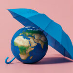 Earth globe protected by blue umbrella symbolizing climate protection