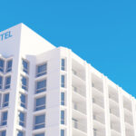 Modern hotel building in the city over blue sky 3d render reside