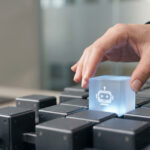 Human hand placing a glowing chatbot cube onto a grid of devices