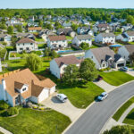 Aerial view of a suburban neighborhood of two-story homes with cars in the driveways