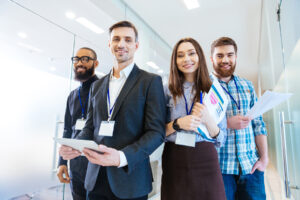 Smiling group of business professionals standing behind their team leader