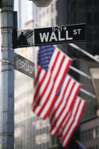 Wall Street street sign with an American flag in the background