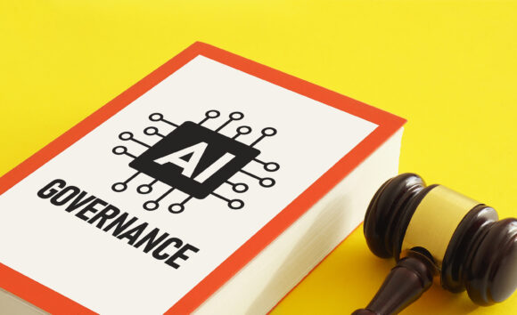 A book labeled "AI Governance" next to a judge's gavel