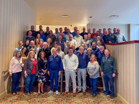 Shepherd Insurance employees pose for a large group photo on a staircase