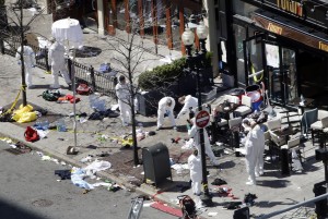 Investigators in haz-mat suits examine the scene of the second bombing on Boylston Street in Boston Tuesday, April 16, 2013 near the finish line of the 2013 Boston Marathon. (AP Photo/Elise Amendola)