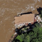 In this aerial photo, a home is pulled into the fast currents of the flooded South Platte River off of U.S 34 between Greeley and Kersey, Colo., Monday, Sept. 16, 2013. Weary Colorado evacuees have begun returning home after days of rain and flooding, but Monday's clearing skies and receding waters revealed only more heartbreak: toppled houses, upended vehicles and a stinking layer of muck covering everything. (AP Photo/The Greeley Tribune, Joshua Polson)